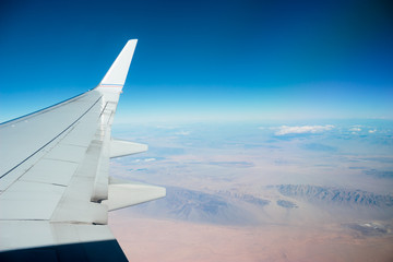 Photo of arid mountains seen through airplane window
