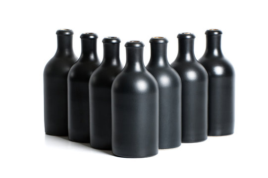 Set of matte black clay bottles on a white background..