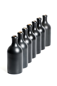 A set of several empty black bottles on a white background close-up..