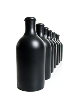 Set of several matte black bottles on a white background..