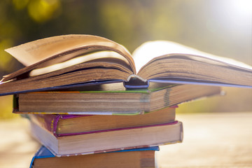 Open book on wooden table on natural background. Soft focus