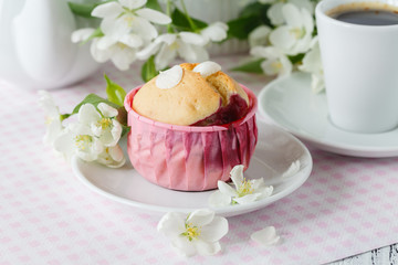Cupcake or muffin with fresh flower in paper cupcake holder