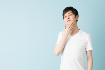 portrait of young asian man isolated on blue background