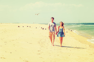 Young American Couple walking, relaxing on the beach in New Jersey, USA