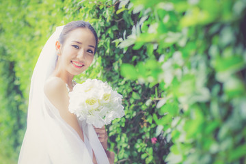 Fototapeta premium beautiful young woman on wedding day in white dress in the tree wall. Female portrait in the park - Selective focus