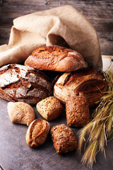 Different kinds of bread and bread rolls on board from above. Ki