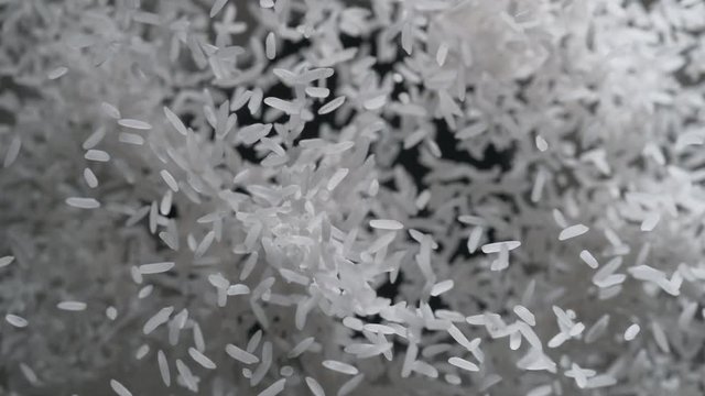 Rice flies after being exploded against black background. Shot with high speed camera, phantom flex 4K. Slow Motion.