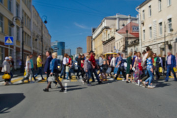 People walk on a pedestrian crossing, blurred background