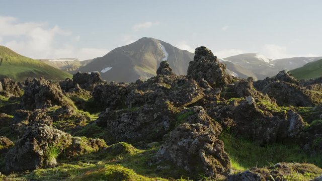 Wide panning shot of green mountain range. Iceland