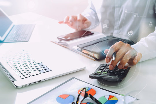 businessman hand working with finances about cost and calculater and latop with mobile phone on withe desk in modern office