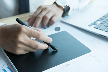 young graphic designer working with computer. creative man using digital tablet and stylus pen at modern office. business, technology, design and people concept