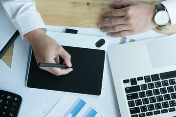 young graphic designer working with computer. creative man using digital tablet and stylus pen at...
