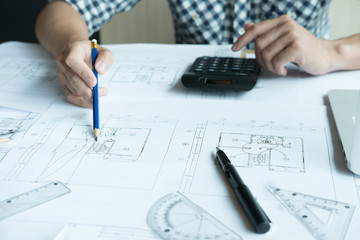 Architect working on real estate project at workplace. Male engineer hand working with living house blueprint at office. Business, people, construction and building concept