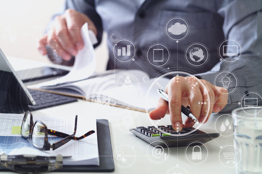 businessman hand working with finances about cost and calculator and latop with mobile phone on withe desk in modern office - Powered by Adobe