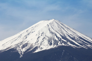 Fototapeta na wymiar The peak of Fuji mountain top filled with white snow and blue sky background.