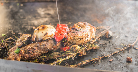 Meat with vegetables frying and smoking at a street food market