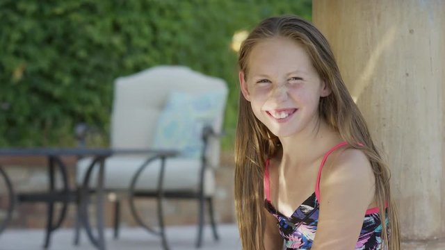 Close up panning shot of girl smiling poolside. Cedar Hills, Utah, United States