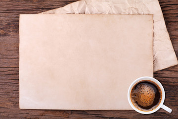 Old blank paper and a cup of coffee on wooden