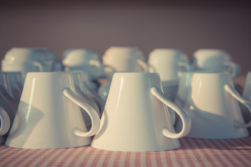 Many white coffee cups in a line buffet for breakfast