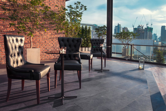 Restaurant dining table and view of business building on terrace at twilight evening time