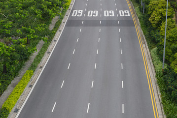 Obraz premium top view of curving road with trees in a public park