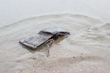 Old Leather Wallet with drowning in beach copy space  