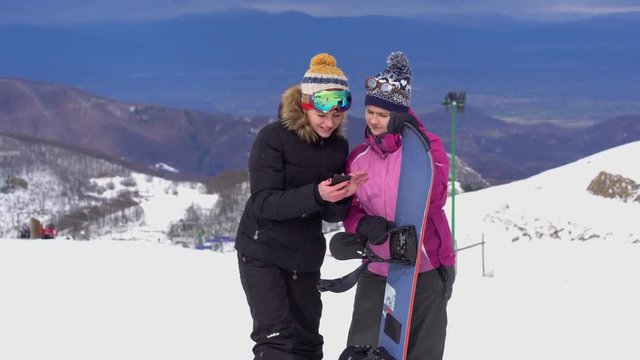 Girls looking at the phone in the mountains