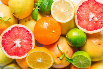 Obraz na płótnie Canvas A large assortment of colorful citrus fruit (lemon, lime, orange, grapefruit, mandarin, tangerine, pomelo)