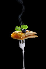 Belgian waffle with honey and blueberry on the fork