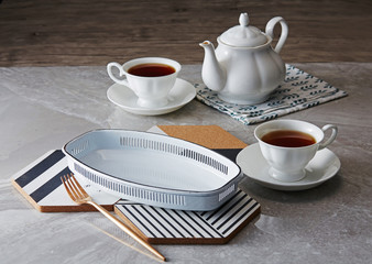 Two cup of tea and teapot on marble table background.