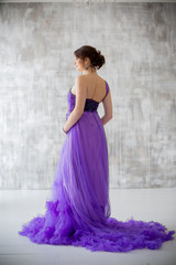 Fototapeta na wymiar beautiful pregnant woman posing in purple dress in Studio
