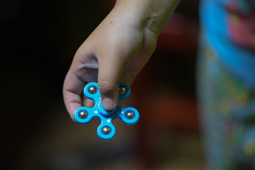 The hands of a child who is playing fidget spinner