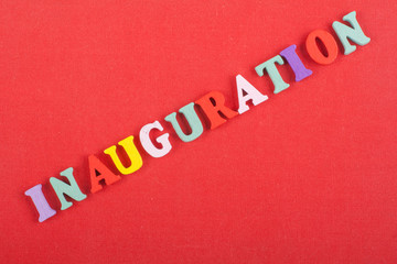 Fototapeta na wymiar Iinauguration . English word on red background composed from colorful abc alphabet block wooden letters, copy space for ad text. Learning english concept.