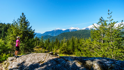 Woman enjoying the Tantalus Mountain Range from a viewpoint along the Sea to Sky Highway between...