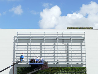 クレーンで作業する男たちと白い壁