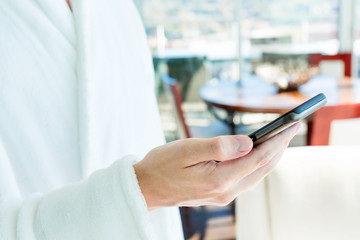 Man in a bathrobe using his smartphone