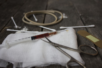 syringe with the drug, bandages, tourniquet, scissors