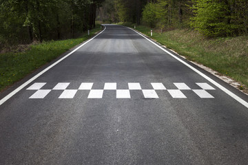 Concept start line pattern symbol painted on the countryside asphalt road floor.