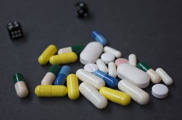 pills on spoon with leaves on a wooden background