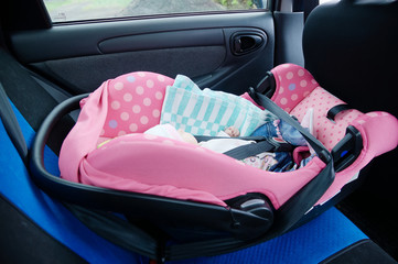 Newborn sleeping in car seat.Safety concept. Infant baby girl. secure driving with children. Baby care lifestyle. Cute baby sleeping in car.