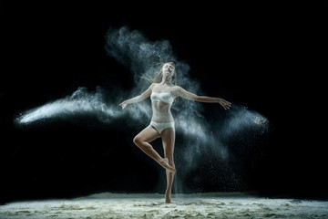 Fototapeta na wymiar Girl in a cloud of white dust studio portrait
