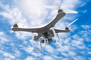Drone with digital camera flying in a blue sky