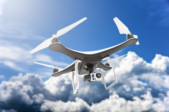 Drone with digital camera flying in a blue cloudy sky