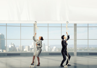 Fototapeta premium Businesswoman pulling banner