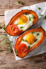 Healthy food: baked sweet potato with fried egg and tomato close-up on the table. vertical top view