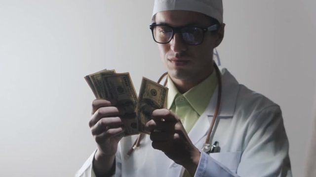 Doctor counts the money. A bribe to a medical worker. Expensive medicine.