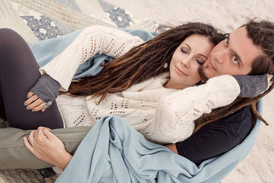 attractive young couple covered with plaid