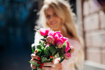 Bouquet of pink peonies in woman's arms