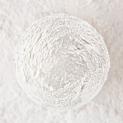 White creamy ice cream ball on white textured background.