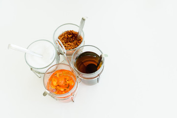 Thai seasoning container include cayenne pepper, sugar, fish sauce and chilies in vinegar on white background with copy space